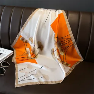 Detailaufnahme des Seidentuchs mit Ginkgoblatt-Muster auf einem Ledersofa