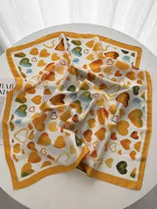 Detailed view of square silk scarf with watercolor heart prints and delicate hem finish