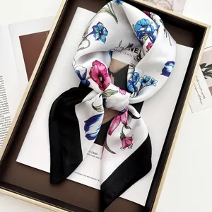 Elegant floral silk scarf with butterfly pattern and black border on a fashion magazine