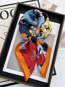 Détail d'un foulard en soie à fleurs avec pétales colorés sur fond bleu marine