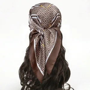 Classic brown and white silk scarf with geometric patterns worn as a stylish headpiece