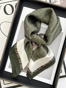 Detalle de elegante pañuelo de seda verde oscuro con estampados geométricos vintage