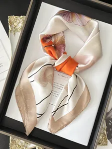 Detail eines Seidenschals mit orangefarbenem Ginkgoblatt-Druck und Satin-Struktur