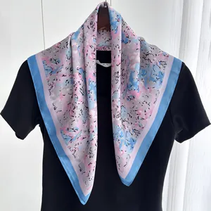 Detail of floral silk scarf in pink and blue draped over a black t-shirt on a hanger