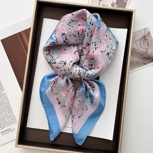 Detailed close-up of a satin silk square scarf with colorful abstract floral patterns