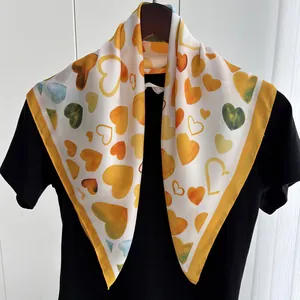 Yellow heart pattern satin square scarf elegantly draped on a clothes hanger