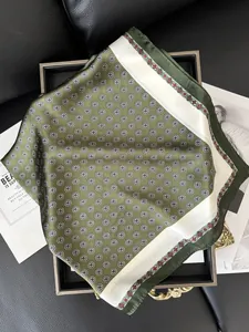Vista detallada de un pañuelo de seda verde esmeralda con diseño vintage en bandeja