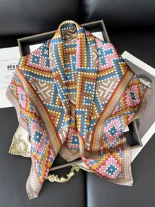 Detailed view of colorful geometric mosaic silk scarf with smooth rolled edges on tray