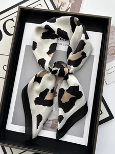 Detailed leopard print silk scarf tied in a knot on a fashion magazine background