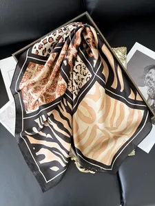 Close-up of leopard and zebra print silk scarf displayed on a luxury magazine