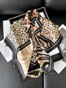 Detail of leopard and zebra print silk scarf on premium black leather texture background
