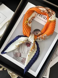 Detail of pleated silk scarf with vintage equestrian print in orange and navy blue