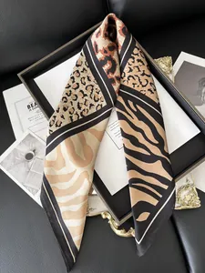 Detail of elegant leopard and zebra print silk scarf on a black display tray