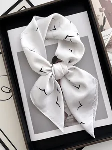 Detail of white silk scarf with black bird prints tied in an elegant decorative bow