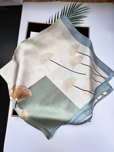 Detail eines Seidenquadrats mit elegantem Ginkgoblattmuster und satinierter Textur