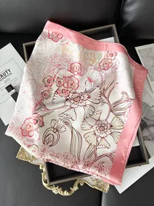 Detail of floral print silk scarf with pink satin border on a luxury display tray