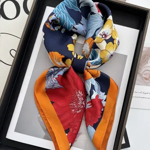 Carré de soie à imprimé floral bleu marine avec bordure orange exposé encadré
