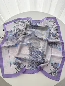 Detailed close-up of light purple floral silk scarf featuring elegant blue and white patterns