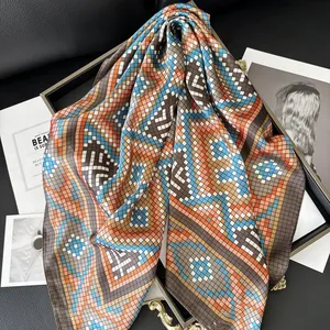 Elegant geometric print faux silk scarf with vibrant mosaic pattern on display tray