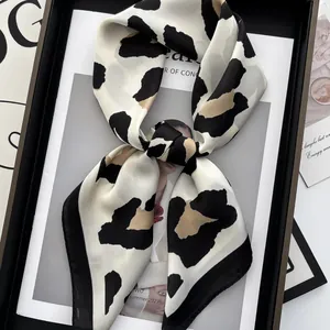Chic leopard print silk square scarf elegantly tied on a fashion magazine background