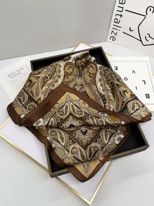 Detailed view of paisley silk scarf with vintage brown patterns on a black display tray