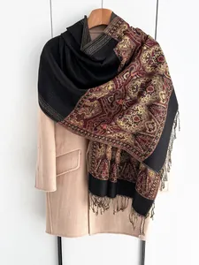 Close-up of ethnic style jacquard shawl with red and gold patterns and tassel edge