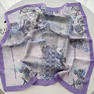 Detail of silk scarf showing elegant floral and chain print with purple rolled edges