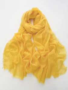 Detailed macro view of bright yellow cotton linen scarf with soft fringe edges