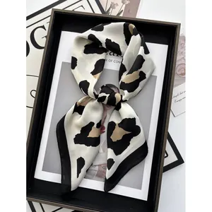 Chic leopard print square silk scarf with black and white paneling on artistic magazine