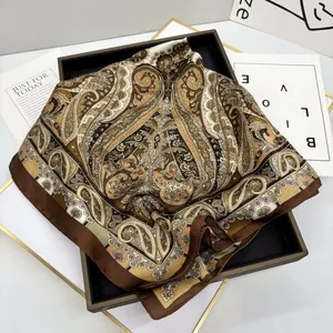 Elegant bohemian paisley silk scarf in vintage beige and brown displayed on a tray