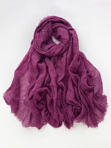 Close-up of dark purple linen scarf with wrinkled texture and natural fringe edges