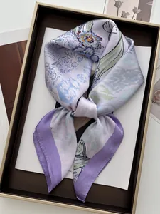 Detail of silk-feel scarf with floral patterns displayed on a luxury display tray