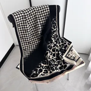 Detail of leopard and houndstooth shawl featuring soft tassels and luxury knit texture