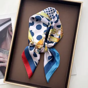 Detailaufnahme eines Seidentuchs mit Polka-Dots und Goldketten-Print im Tablett