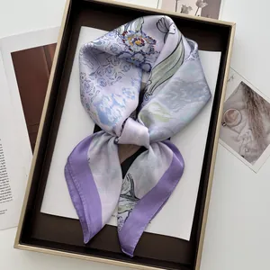 Detail of floral printed satin square scarf knotted in a tray with elegant lavender tones