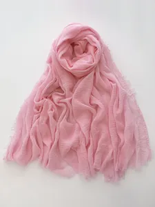 Detail of light pink cotton linen scarf featuring breathable fabric and raw fringe edges