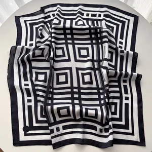 Dettaglio dei motivi geometrici a righe su un elegante foulard di seta quadrato da donna