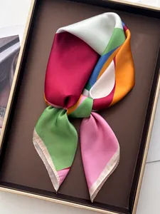 Detail of silk-like satin scarf with geometric color block patterns in a gift box