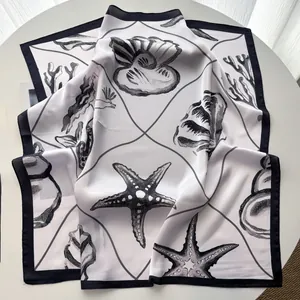 Detailed view of square silk scarf with black borders and hand-drawn starfish and shells