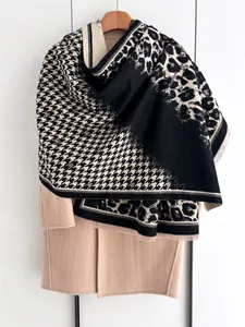 Detail of leopard and houndstooth pattern patchwork on soft knit shawl with fringe