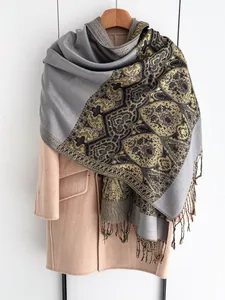 Detail of ethnic jacquard shawl with intricate paisley patterns and long tassel fringe