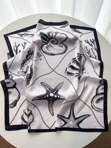 Detailed view of marine starfish pattern on elegant silk scarf with black contrast border