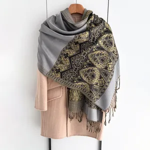 Close-up of vintage totem pattern on thick gray shawl scarf with elegant fringe trim