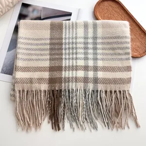 Détail d'une écharpe à carreaux beige et marron avec franges douces et texture de qualité