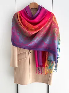 Detail van kleurrijke paisley sjaal met regenboogverloop en handgeknoopte franjes