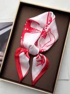 Close-up of silk scarf with red starfish print tied in a bow on a luxury display tray