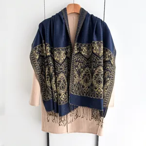Macro detail of dark blue ethnic scarf with gold jacquard patterns and soft fringe