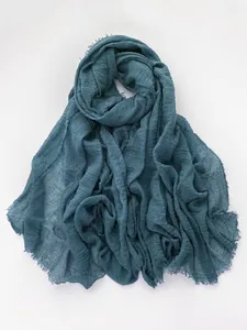 Detail of teal cotton linen scarf featuring crinkle texture and raw frayed edges
