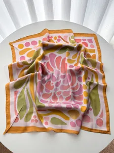 Close-up of a geometric paisley silk scarf with artistic pink and orange patterns
