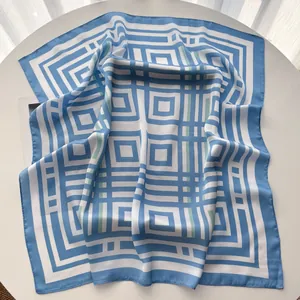 Dettaglio di un foulard in seta a righe con motivi geometrici blu e bianchi